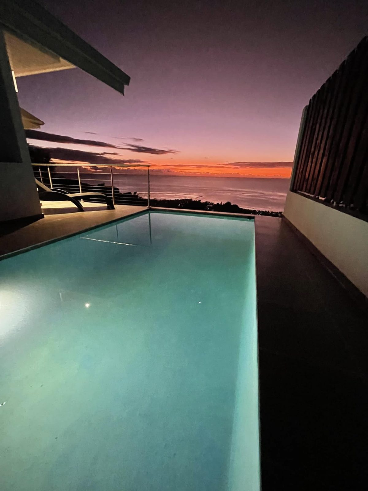 Piscine privée de la villa au crépuscule, face à l'océan